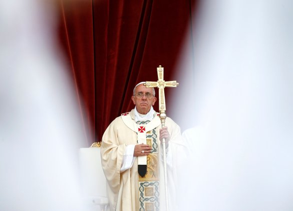 Pope Francis is seen through the vests of celebrants he leads at the feast of Corpus Christi at St. Givanni in Laterano Basilica in Rome