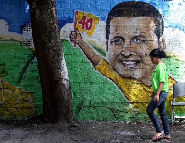 Una mujer camina junto a un mural con la imagen del fallecido candidato presidencial brasileño Eduardo Campos hoy, jueves 14 de agosto de 2014, en Recife (Brasil), donde la sede de campaña del candidato permanece de luto en homenaje a él. Campos murió ayer en un accidente aéreo en una zona residencial de la ciudad de Santos. El dirigente del Partido Socialista Brasileño (PSB) estaba a bordo de la avioneta, junto con otros miembros de su campaña electoral, de los que ninguno sobrevivió. EFE/Fernando Bizerra Jr.