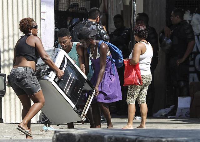 Centenares de familias que invadieron una fábrica abandonada en el Conjunto de Favelas de Alemán hace siete meses son desalojadas por la Policía brasileña hoy, martes 16 de diciembre de 2014, en la ciudad de Río de Janeiro. (foto EFE/ Antonio Lacerda)