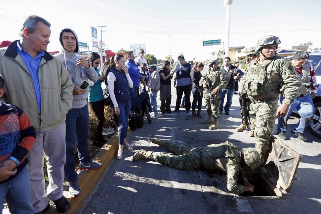 A soldier tries pull out a weapon found in a drain from where Joaquin "El Chapo" Guzman escaped before being captured at Jiquilpan Boulevard in Los Mochis, in Sinaloa state, Mexico, January 9, 2016. Mexico's government aims to fulfill a request from the United States to extradite the newly-recaptured drug lord Guzman to face drug trafficking charges, sources familiar with the situation said on Saturday. REUTERS/Edgard Garrido