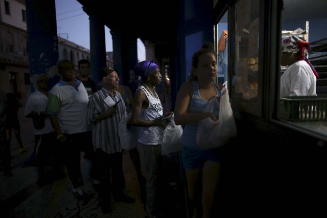 People line up to buy bread at a subsidised state store, or "bodega", where Cubans can buy basic products with a ration book they receive annually from the government, in downtown Havana December 29, 2015. REUTERS/Alexandre Meneghini