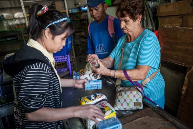 CAR01. CARACAS (VENEZUELA), 16/01/2016.- Clientes hacen fila para pagar productos que compraron en un abasto hoy, sábado 16 de enero de 2016, en la ciudad de Caracas (Venezuela). Venezuela, con las mayores reservas probadas de petróleo del mundo, se declaró en emergencia económica para atender la situación del país que después de un año de opacidad reveló una inflación interanual de 141,5 por ciento -la más alta de toda su historia-, y una contracción del 4,5 por ciento. EFE/MIGUEL GUTIÉRREZ