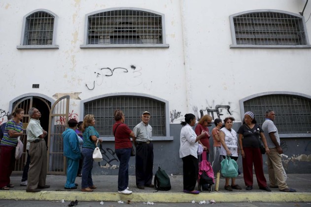 People wait in a line for the elderly outside a PDVAL, a state-run supermarket, to buy chicken in Caracas January 22, 2016.  Venezuela's opposition refused on Friday to approve President Nicolas Maduro's "economic emergency" decree in Congress, saying it offered no solutions for the OPEC nation's increasingly disastrous recession. Underlining the grave situation in Venezuela, where a plunge in oil prices has compounded dysfunctional policies, the International Monetary Fund on Friday forecast an 8 percent drop in gross domestic product and 720 percent inflation this year. REUTERS/Carlos Garcia Rawlins