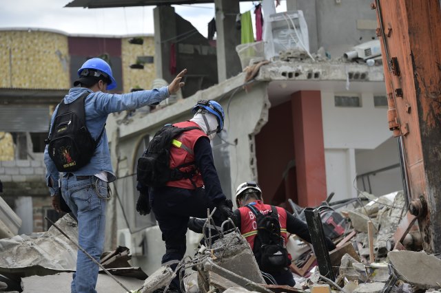 Rescue workers search the rubble in Pedernales, Ecuador on April 17, 2016 after a 7.8-magnitude quake hit the city the day before. At least 233 people have been killed in the 7.8-magnitude earthquake that struck Ecuador's Pacific coast, President Rafael Correa said Sunday. / AFP PHOTO / RODRIGO BUENDIA