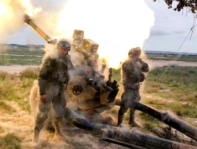 Momento del disparo de un obús Light Gun L118 durante el desarrollo de la demostración táctica que la Brigada de Infantería Ligera 'Galicia' VII (Brilat) realiza junto a otras unidades internacionales en el Centro de Adiestramiento 'San Gregorio', con motivo de su preparación como punta de lanza (VJTF) de la Fuerza de Respuesta de la OTAN para 2016 (NRF). EFE/Javier Cebollada