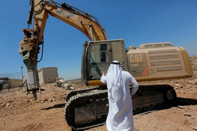 Un palestino trata de detener las máquinas excavadoras israelíes durante una operación de limpieza de sus tierras en el poblado de DerQedes, al noroeste de la ciudad de Ramala, hoy, 13 de julio de 2016. EFE/Alaa Badarneh