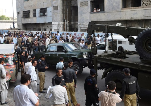 Una grúa levanta un vehículo del ejército en el sitio de un ataque de hombres armados en Karachi el 26 de julio de 2016. Dos soldados paquistaníes fueron asesinados a tiros el 26 de julio, cuando dos hombres armados en una motocicleta abrieron fuego contra su camioneta pick-up en la ciudad meridional de Karachi, dijeron las autoridades. AFP PHOTO / ASIF HASSAN