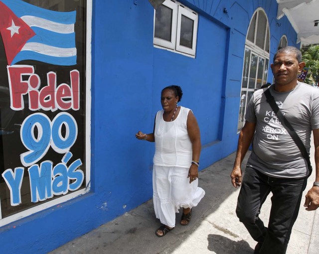 HAB101. LA HABANA (CUBA), 09/08/2016.- Dos personas caminan hoy, martes 09 de agosto del 2016, en La Habana (Cuba), junto a un mensaje alusivo al cumpleaños 90 del líder de la revolución cubana Fidel Castro este próximo sábado 13 de agosto. EFE/Ernesto Mastrascusa