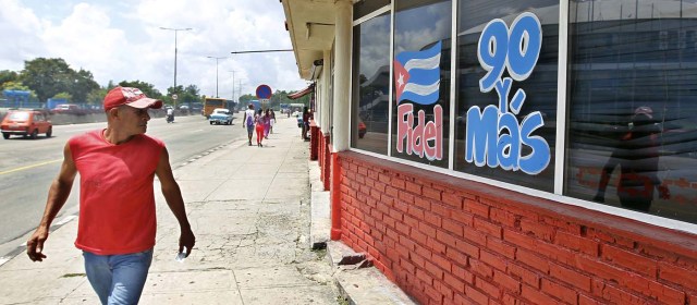 HAB101. LA HABANA (CUBA), 09/08/2016.- Un hombre camina hoy, martes 09 de agosto del 2016, en La Habana (Cuba), junto a un mensaje alusivo al cumpleaños 90 del líder de la revolución cubana Fidel Castro este próximo sábado 13 de agosto. EFE/Ernesto Mastrascusa