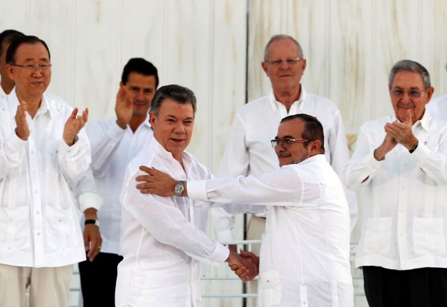 Foto del lunes del presidente de Colombia, Juan Manuel Santos (I), y el líder de las FARC, Timochenko, estrechando sus manos tras firmar el acuerdo de paz en Cartagena. Sep 26, 2016. El presidente colombiano, Juan Manuel Santos, y el líder de la guerrilla de las FARC, Rodrigo Londoño, firmaron el lunes un histórico acuerdo para acabar con un conflicto armado que desangró a Colombia durante más de medio siglo. REUTERS/John Vizcaino