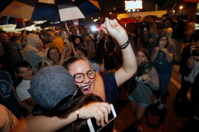 Cuban Americans celebrate upon hearing about the death of longtime Cuban leader Fidel Castro in the Little Havana neighborhood of Miami, Florida on November 26, 2016. Cuba's socialist icon and father of his country's revolution Fidel Castro died on November 25 aged 90, after defying the US during a half-century of ironclad rule and surviving the eclipse of global communism. / AFP PHOTO / RHONA WISE