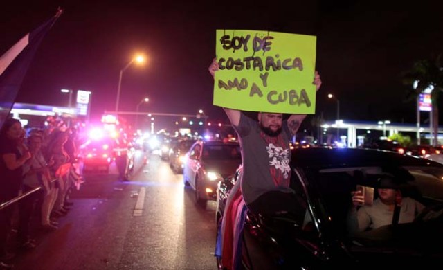 People celebrate after the announcement of the death of Cuban revolutionary leader Fidel Castro, in the Little Havana district of Miami, Florida, U.S. November 26, 2016. The placard reads, "I am from Costa Rica and I love you Cuba". REUTERS/Javier Galeano