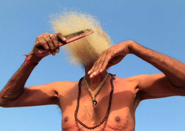 FILE PHOTO - A Sadhu or Hindu holy man combs his beard after taking a dip in the waters of Shipra river during Simhastha Kumbh Mela in Ujjain, India May 16, 2016. REUTERS/Jitendra Prakash/File Photo REUTERS PICTURES OF THE YEAR 2016 - SEARCH 'POY 2016' TO FIND ALL IMAGES