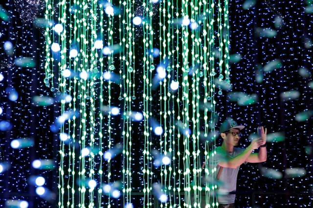 A man tours a Christmas attraction featuring a display of more than 800,000 light bulbs in Universal Studios Singapore December 12, 2016. REUTERS/Edgar Su