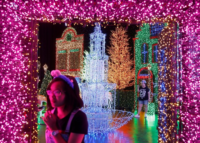People tour a Christmas attraction featuring a display of more than 800,000 light bulbs in Universal Studios Singapore December 12, 2016. REUTERS/Edgar Su