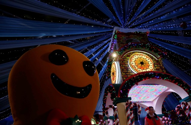 A performer dressed as a gingerbread man dances with people at a Christmas attraction in Universal Studios Singapore December 12, 2016. REUTERS/Edgar Su