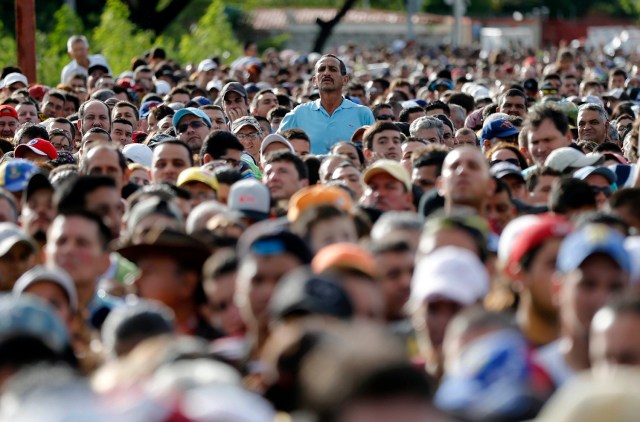 En esta imagen de archivo, tomada el 17 de julio de 2016, un hombre sobresale entre la multitud para echar un vistazo mientras esperan para cruzar la frontera con Colombia en el puente Simón Bolívar desde San Antonio del Táchira, Venezuela. Decenas de miles de venezolanos pasaron a Colombia ese día para comprar comida y medicamentos. (AP Foto/Ariana Cubillos, archivo)