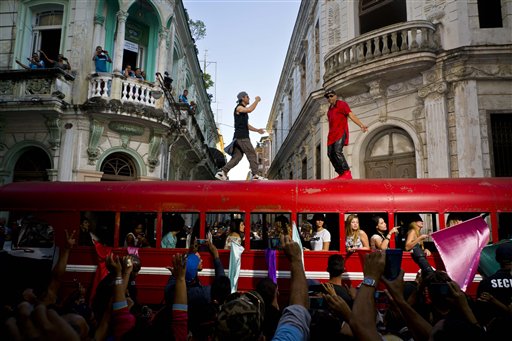 En esta fotografía del miércoles 11 de enero de 2017, el cantante español Enrique Iglesias, al centro, y el cantante cubano Descember Bueno bailan arriba de un autobús durante la filmación de un video en La Habana Vieja, Cuba. Las imágenes acompañarán un tema de Enrique Iglesias que saldrá a la venta este año. (AP Foto/Ramón Espinosa)
