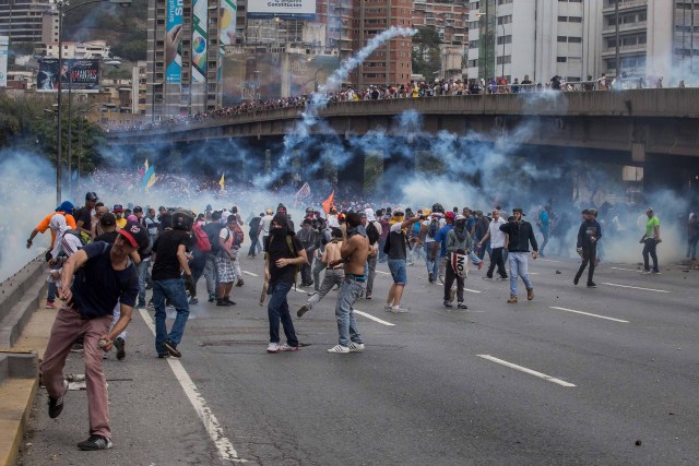 CAR01. CARACAS (VENEZUELA), 06/04/2017 - Un grupo de personas participa en una manifestación de opositores al gobierno de Nicolás Maduro hoy, jueves 6 de abril de 2017, en Caracas (Venezuela). La Policía Nacional Bolivariana (PNB) dispersó hoy con gases lacrimógenos y agua una marcha opositora en Caracas que pretendía llegar hasta la Defensoría del Pueblo para pedir su respaldo al proceso iniciado por el Parlamento contra siete magistrados del Tribunal Supremo de Justicia (TSJ). EFE/MIGUEL GUTIERREZ