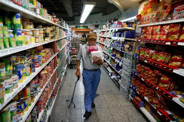 A man carries toilet paper at a supermarket in Caracas May 17, 2013. Supplies of food and other basic products have been patchy in recent months, with long queues forming at supermarkets and rushes occurring when there is news of a new stock arrival. The situation has spawned jokes among Venezuelans, particularly over the lack of toilet paper. The government announced this week it was importing 50 million rolls to compensate for "over-demand due to nervous buying." REUTERS/Jorge Silva (VENEZUELA - Tags: POLITICS SOCIETY)