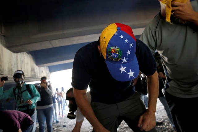 Venezuelan opposition leader and Governor of Miranda state Capriles tries to catch his breath after being affected by tear gas while participating in the so-called "mother of all marches" against Venezuela's President Nicolas Maduro in Caracas