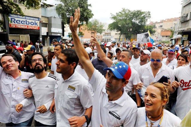 Lawmakers walk together with Venezuelan opposition leader and Governor of Miranda state Henrique Capriles (2nd R) and Lilian Tintori, wife of jailed opposition leader Leopoldo Lopez, as they take part in a rally to honour victims of violence during a protest against Venezuela's President Nicolas Maduro's government in Caracas, Venezuela, April 22, 2017. REUTERS/Carlos Garcia Rawlins