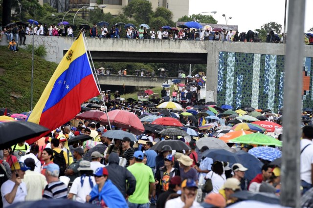 Venezuelan opposition activists carry out a protest against the government of President Nicolas Maduro, in Caracas, on May 15, 2017. Venezuela's opposition Sunday urged the armed forces to consider dialogue, despite its loyalty to embattled President Nicolas Maduro in the country's deadly political crisis. / AFP PHOTO / JUAN BARRETO