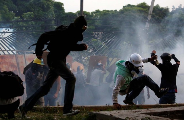 Military police take position at an air base as opposition supporters clash with them while rallying against President Nicolas Maduro in Caracas, Venezuela, May 8, 2017. REUTERS/Carlos Garcia Rawlins