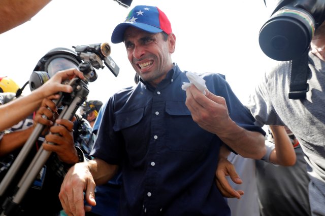 Venezuela opposition leader and Governor of Miranda state Henrique Capriles (C) reacts as he is affected by tear gas while rallying against Venezuela's President Nicolas Maduro in Caracas, Venezuela, May 10, 2017. REUTERS/Carlos Garcia Rawlins
