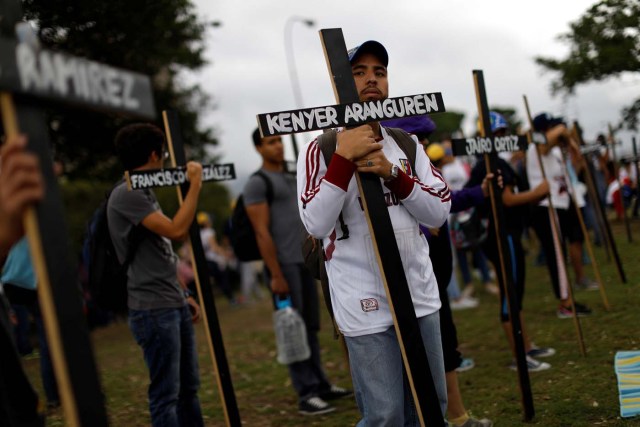 Opposition supporters hold crosses with the names of victims of violence during the protests against Venezuela's President Nicolas Maduro's government, during a protest in Caracas, Venezuela May 15, 2017. REUTERS/Carlos Garcia Rawlins