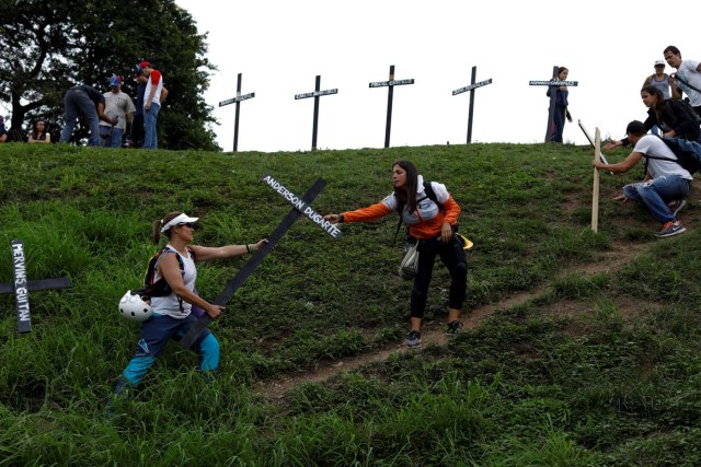 Opposition supporters carry crosses with the names of victims of violence during the protests against Venezuela's President Nicolas Maduro's government, during a protest in Caracas, Venezuela May 15, 2017. REUTERS/Carlos Garcia Rawlins