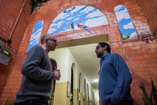 El venezolano Carlos Escalona, de 33 años, conversa con el sacerdote italiano Paolo Parise (L), responsable del centro de refugiados de Missao Paz, en Sao Paulo, Brasil, el 17 de mayo de 2017. Escalona huyó cuando recibió amenazas luego de descubrir la corrupción en la institución pública venezolana donde trabajó y ahora busca asilo en Brasil. Miles de venezolanos han abandonado su país para escapar de las dificultades y la violencia de su crisis económica y política. De Brasil a Estados Unidos a Europa, aquí hay cinco caras y voces de estos venezolanos que se han exiliado en los últimos dos años.   / AFP PHOTO / NELSON ALMEIDA / VAN CON LA HISTORIA AFP "Los venezolanos en el exilio: cinco caras de la crisis"