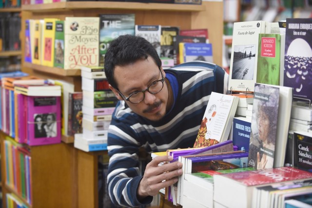 El venezolano Jairo Rojas, de 36 años, trabaja en una librería en Montevideo el 31 de mayo de 2017. Rojas se trasladó en abril de 2015 a Uruguay, donde publicó tres libros de poesía, ganó premios de poesía y lanzó una operación de publicación de versos con sus amigos. Miles de venezolanos han abandonado su país para escapar de las dificultades y la violencia de su crisis económica y política. De Brasil a Estados Unidos a Europa, aquí hay cinco caras y voces de estos venezolanos que se han exiliado en los últimos dos años. / AFP PHOTO / MIGUEL ROJO / PARA IR CON LA HISTORIA AFP "Los venezolanos en el exilio: cinco caras de la crisis"