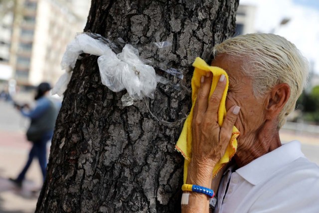 A woman reacts to tear gas during a rally against Venezuela's President Nicolas Maduro's government in Caracas, Venezuela June 14, 2017.  REUTERS/Carlos Garcia Rawlins