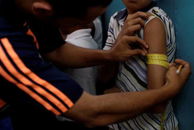 Un maestro mide el brazo de un niño como parte de un programa de salud del gobierno del estado de Miranda en una escuela en Caracas, Venezuela el 25 de marzo de 2017. Fotografía tomada el 25 de marzo de 2017. REUTERS / Marco Bello