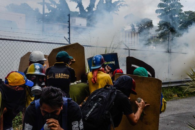 Venezuelan opposition activists clash with riot police during a protest against Venezuelan President Nicolas Maduro in Caracas on July 10, 2017.  Venezuela hit its 100th day of anti-government protests Sunday, amid uncertainty over whether the release from prison a day earlier of prominent political prisoner Leopoldo Lopez might open the way to negotiations to defuse the profound crisis gripping the country. / AFP PHOTO / FEDERICO PARRA