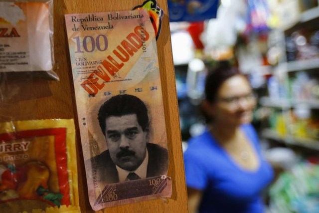 Foto de archivo: Ejemplo de un billete de 100 bolívares con la cara del presidente de Venezuela, Nicolás Maduro, se ve en un mercado en Caracas, Venezuela, tomada el 13 de febrero de 2015. REUTERS/Jorge Silva (VENEZUELA - Tags: POLITICS BUSINESS) - RTR4PH3V