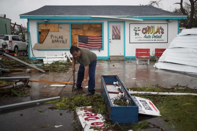 Business owner and resident Carlos Lopez clears debris from outside his shop which was hit by Hurricane Harvey in Rockport, Texas, U.S. August 26, 2017. REUTERS/Adrees Latif