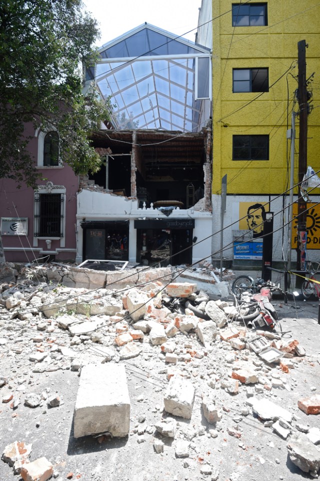 Picture of debris of the facade of a building which collapsed when a quake rattled Mexico City on September 19, 2017. A powerful earthquake shook Mexico City on Tuesday, causing panic among the megalopolis' 20 million inhabitants on the 32nd anniversary of a devastating 1985 quake. The US Geological Survey put the quake's magnitude at 7.1 while Mexico's Seismological Institute said it measured 6.8 on its scale. The institute said the quake's epicenter was seven kilometers west of Chiautla de Tapia, in the neighboring state of Puebla. / AFP PHOTO / Alfredo ESTRELLA