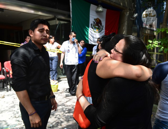 People react after a quake rattled Mexico City on September 19, 2017. A powerful earthquake shook Mexico City on Tuesday, causing panic among the megalopolis' 20 million inhabitants on the 32nd anniversary of a devastating 1985 quake. The US Geological Survey put the quake's magnitude at 7.1 while Mexico's Seismological Institute said it measured 6.8 on its scale. The institute said the quake's epicenter was seven kilometers west of Chiautla de Tapia, in the neighboring state of Puebla. / AFP PHOTO / Ronaldo SCHEMIDT