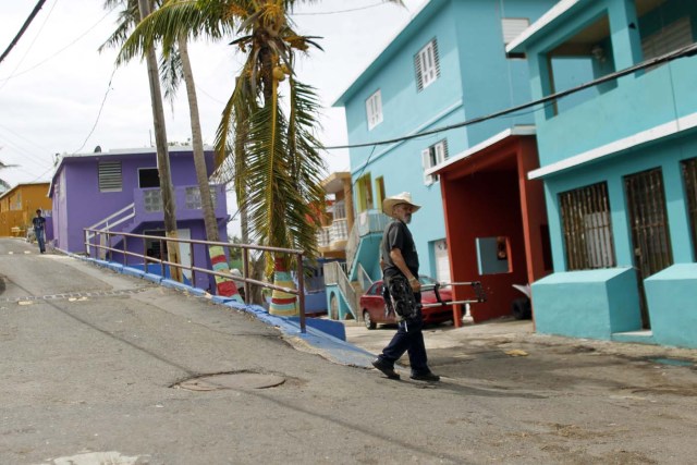 A man walks on a street in the neighbourhood of La Perla in the aftermath of Hurricane Maria in San Juan, Puerto Rico, on September 22, 2017. Puerto Rico battled dangerous floods Friday after Hurricane Maria ravaged the island, as rescuers raced against time to reach residents trapped in their homes and the death toll climbed to 33. / AFP PHOTO / Ricardo ARDUENGO
