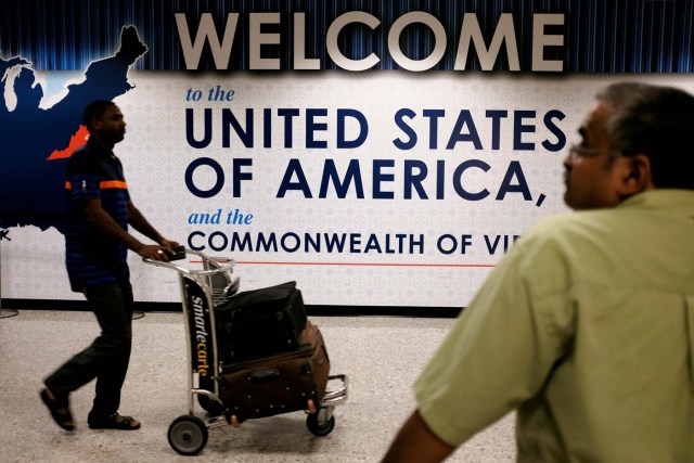 Un pasajero llega al aeropuerto internacional de Dulles mientras una persona espera en el área de arribos en Dulles, Virginia, EEUU. 24 de septiembre, 2017. REUTERS/James Lawler Duggan