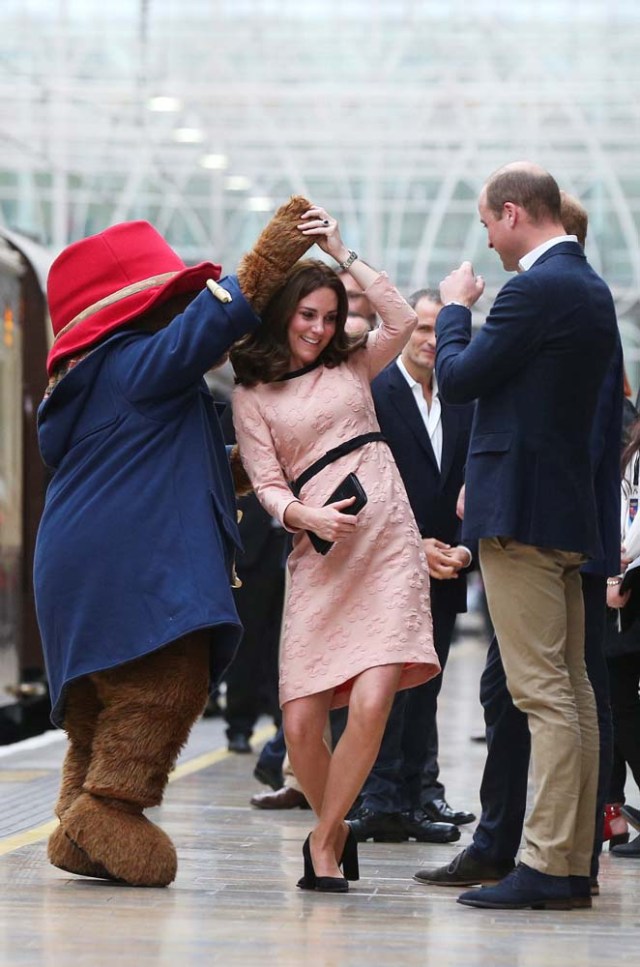 Britain's Prince William watches as his wife Catherine the Duchess of Cambridge dances with a costumed figure of Paddington bear on platform 1 at Paddington Station, as they attend the Charities Forum in London, October 16, 2017. REUTERS/Jonathan Brady/Pool