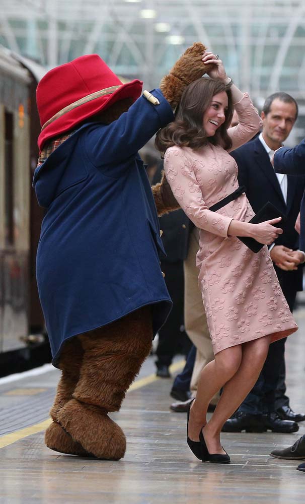 Britain's Catherine the Duchess of Cambridge dances with a costumed figure of Paddington bear on platform 1 at Paddington Station, as they attend the Charities Forum in London, October 16, 2017. REUTERS/Jonathan Brady/Pool