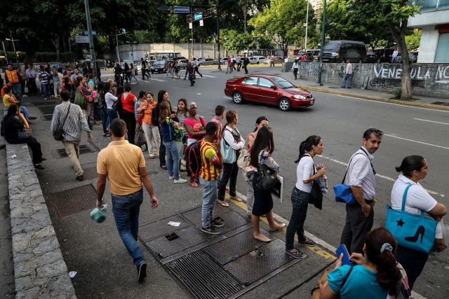 Fotografías del 10 de octubre del 2017, de decenas de personas que hacen fila para esperar un bus de transporte público en la ciudad de Caracas (Venezuela). Los altos costos de mantenimiento, la disminución de importación de repuestos, una galopante inflación y la escasez de efectivo tienen al sistema de transporte de Venezuela en jaque, mientras la población padece los efectos de esta crisis con un pasaje inestable y largos tiempos de espera para trasladarse. EFE/MIGUEL GUTIÉRREZ