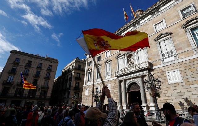 Spanish and Catalan separatist flags are waved in front of the Generalitat Palace, the Catalan regional government headquarters in Barcelona, Spain, October 30, 2017. REUTERS/Juan Medina
