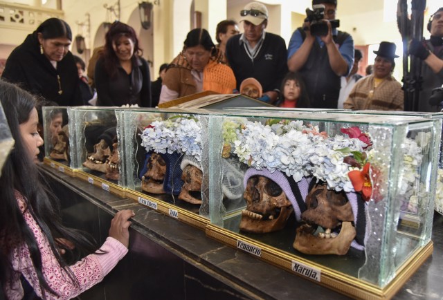 Devotees have their "natitas" (snub-nosed) human skulls blessed at the Central Cemetery's chapel in La Paz, during the annual traditional ritual on November 8, 2017. The "natitas" are meant to protect their owners, who keep them at home all year long and bring them to the cemetery chapels every November 8 to perform rituals which end up in a traditional party. / AFP PHOTO / Aizar RALDES
