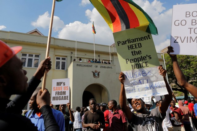 EPA3247. HARARE (ZIMBABWE), 21/11/2017.- Manifestantes protestan en las inmediaciones del Parlamento en Harare (Zimbabue) hoy, 21 de noviembre de 2017. El Parlamento celebra hoy una sesión para tratar una moción de censura contra el presidente, Robert Mugabe. EFE/ Kim Ludbrook