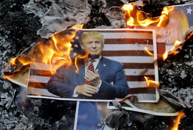 A portrait of US President Donald Trump burns during a demonstration in the capital Tehran on December 11, 2017 to denounce his declaration of Jerusalem as Israel's capital.  / AFP PHOTO / ATTA KENARE