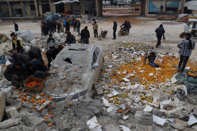 People collect scattered oranges amidst rubble after an airstrike on a market in rebel held Maarrat Misrin city in Idlib province, Syria January 14, 2017. REUTERS/Ammar Abdullah/File Photo      SEARCH "POY GLOBAL" FOR THIS STORY. SEARCH "REUTERS POY" FOR ALL BEST OF 2017 PACKAGES.    TPX IMAGES OF THE DAY